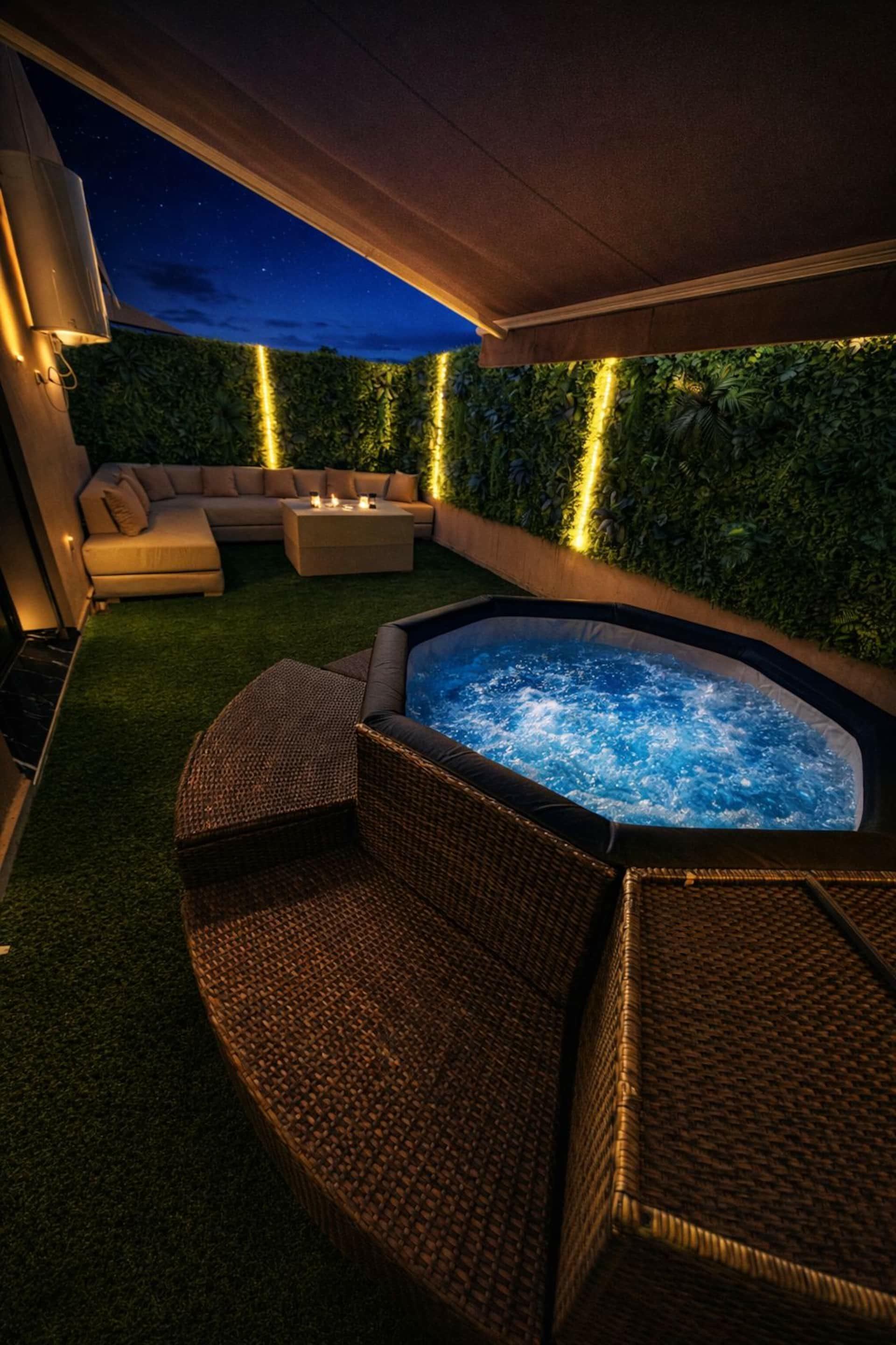 Jacuzzi del Studio Garden al anochecer, con el salón exterior al fondo