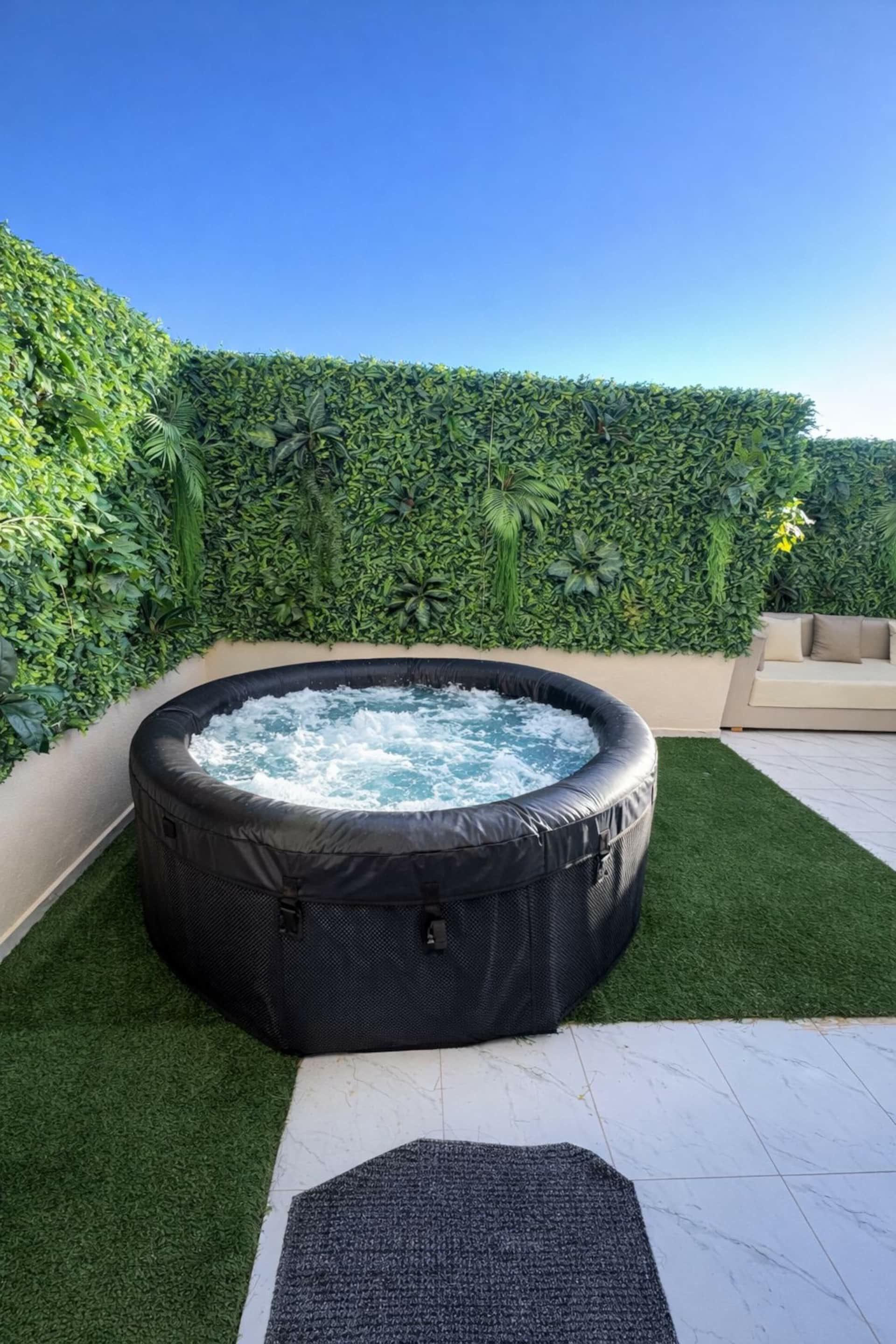 Jacuzzi chauffant devant le mur végétal